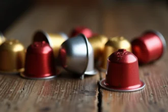 Capsules compatibles Nespresso de différentes marques disposées sur une surface en bois, comparaison qualité-prix des dosettes alternatives