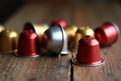 Capsules compatibles Nespresso de différentes marques disposées sur une surface en bois, comparaison qualité-prix des dosettes alternatives